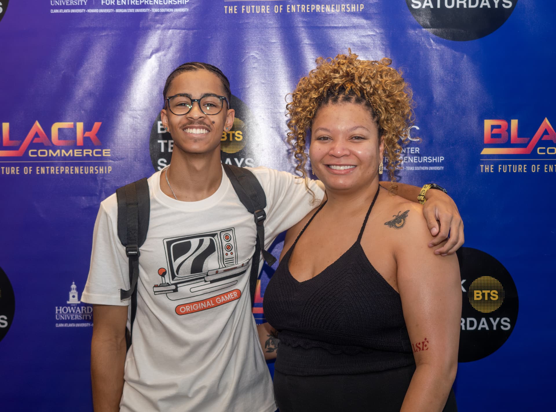 Two guests posing together on the Black Tech Saturdays step-and-repeat backdrop