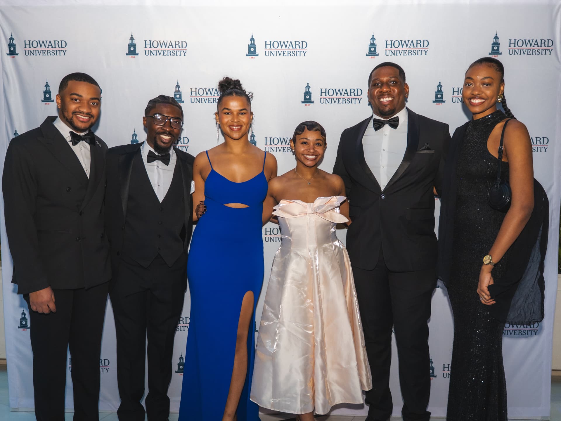 Group of six guests in formalwear on the Howard University step-and-repeat