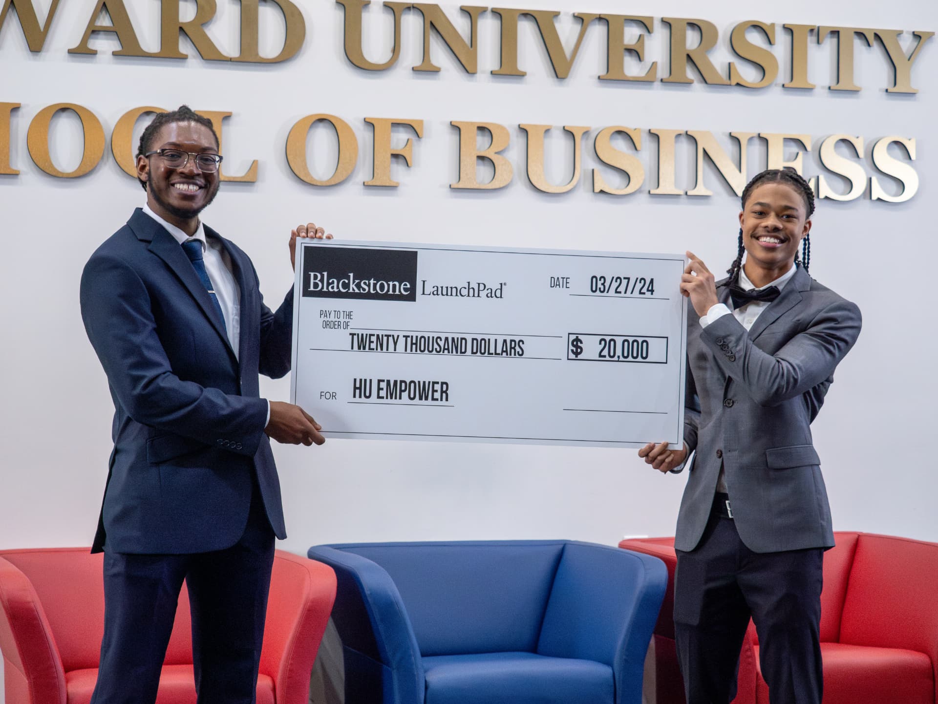 Two students presenting a twenty thousand dollar award check