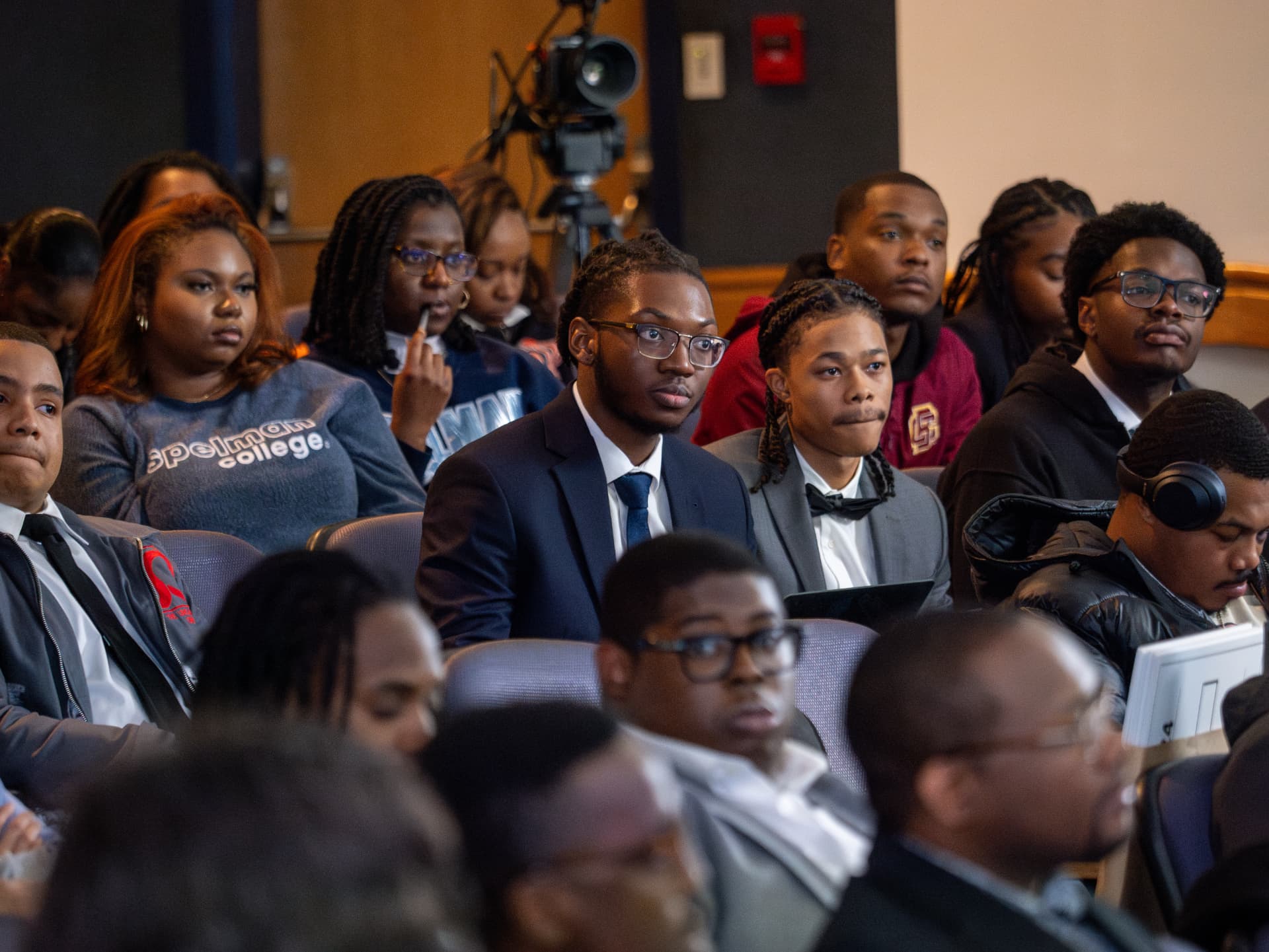 Students listening attentively in a packed auditorium