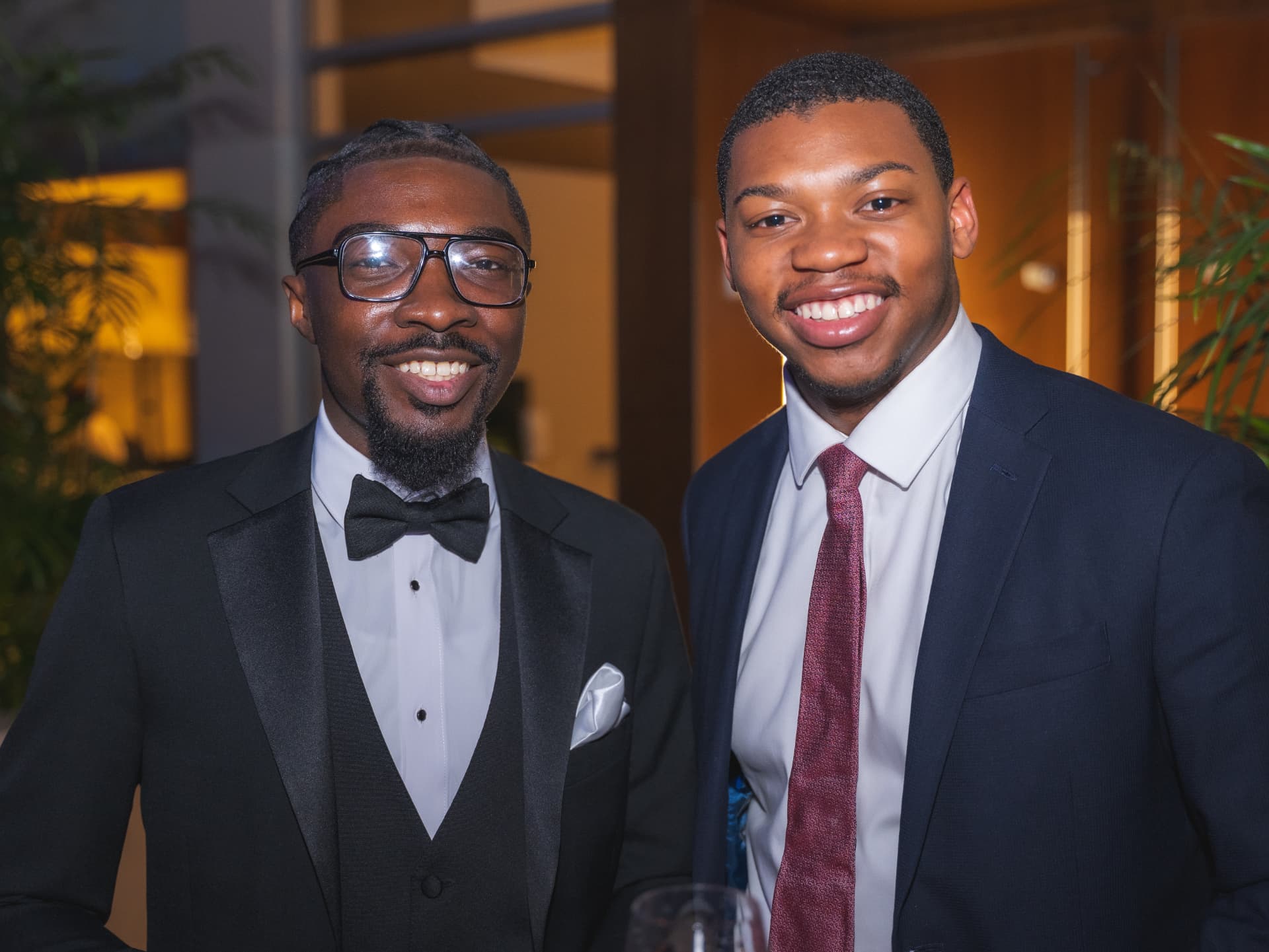Two guests in tuxedos smiling together during the reception
