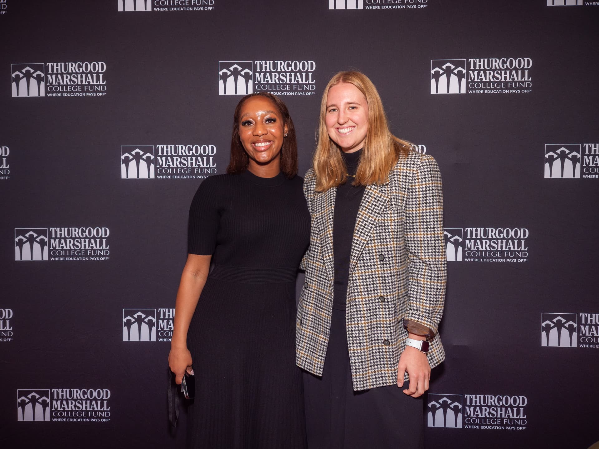 Two women posing together on the Thurgood Marshall College Fund step-and-repeat