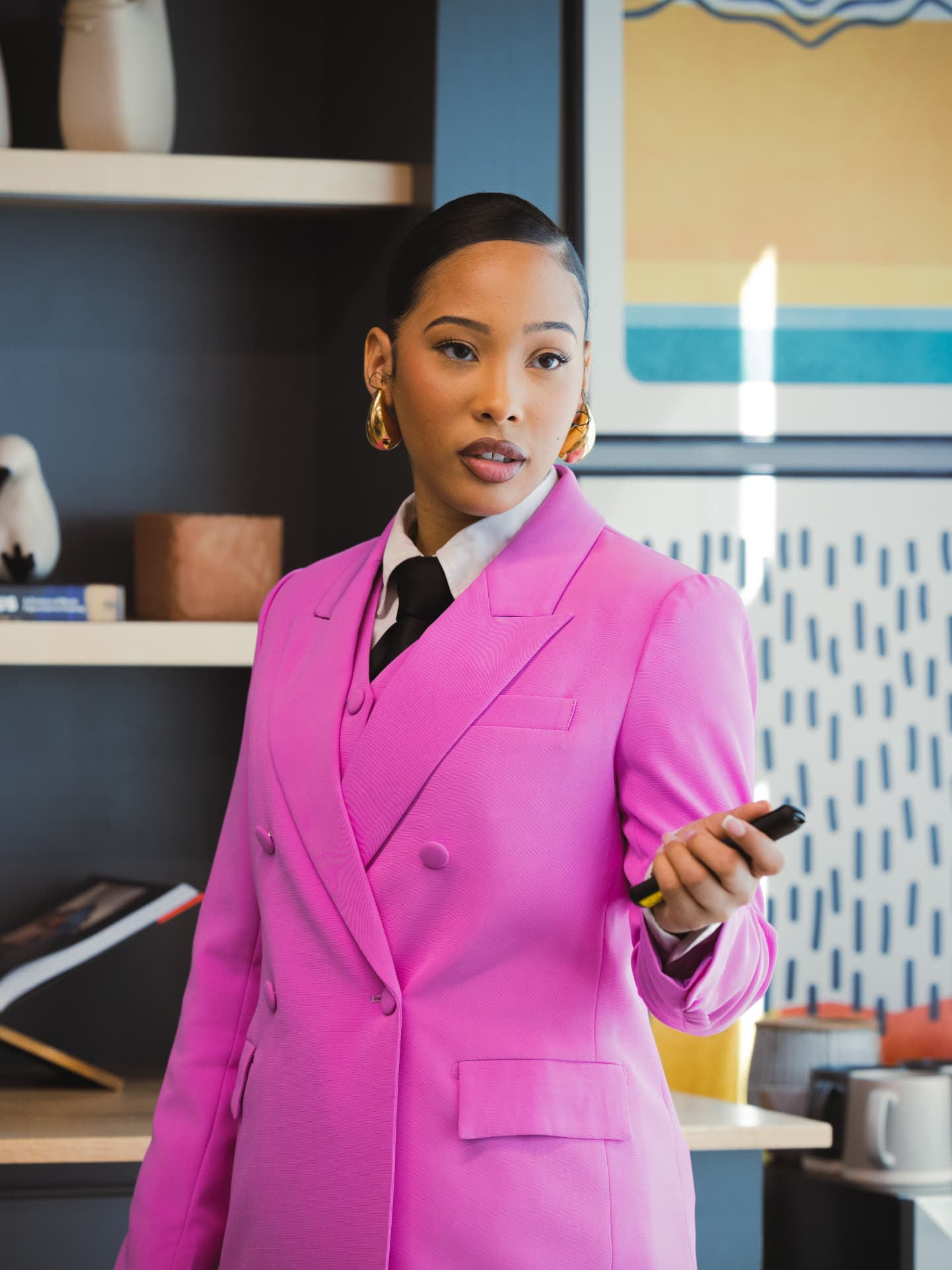 Woman in a bright pink suit speaking on camera during a branded video shoot