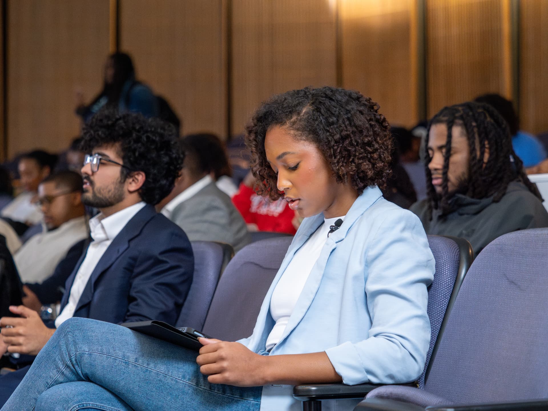 Attendees seated in an auditorium during a panel session