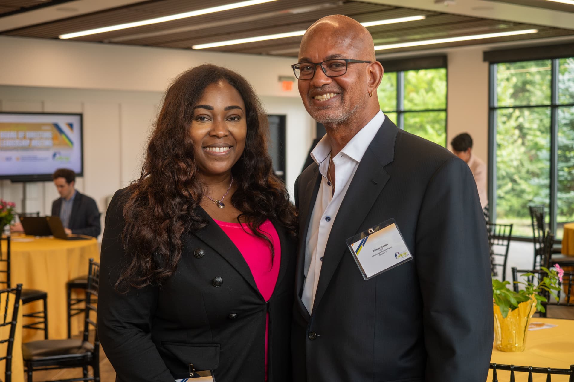 Two attendees smiling together at a board of directors leadership meeting