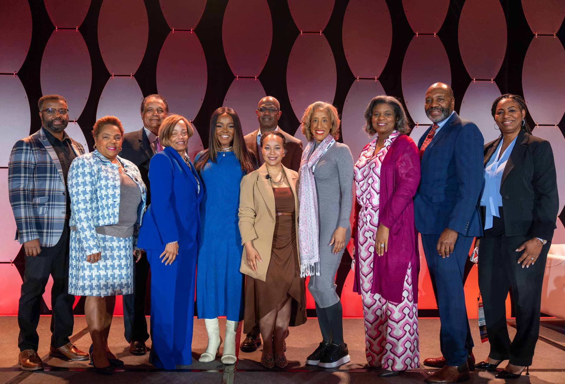 Group of speakers posing together on stage at the conference