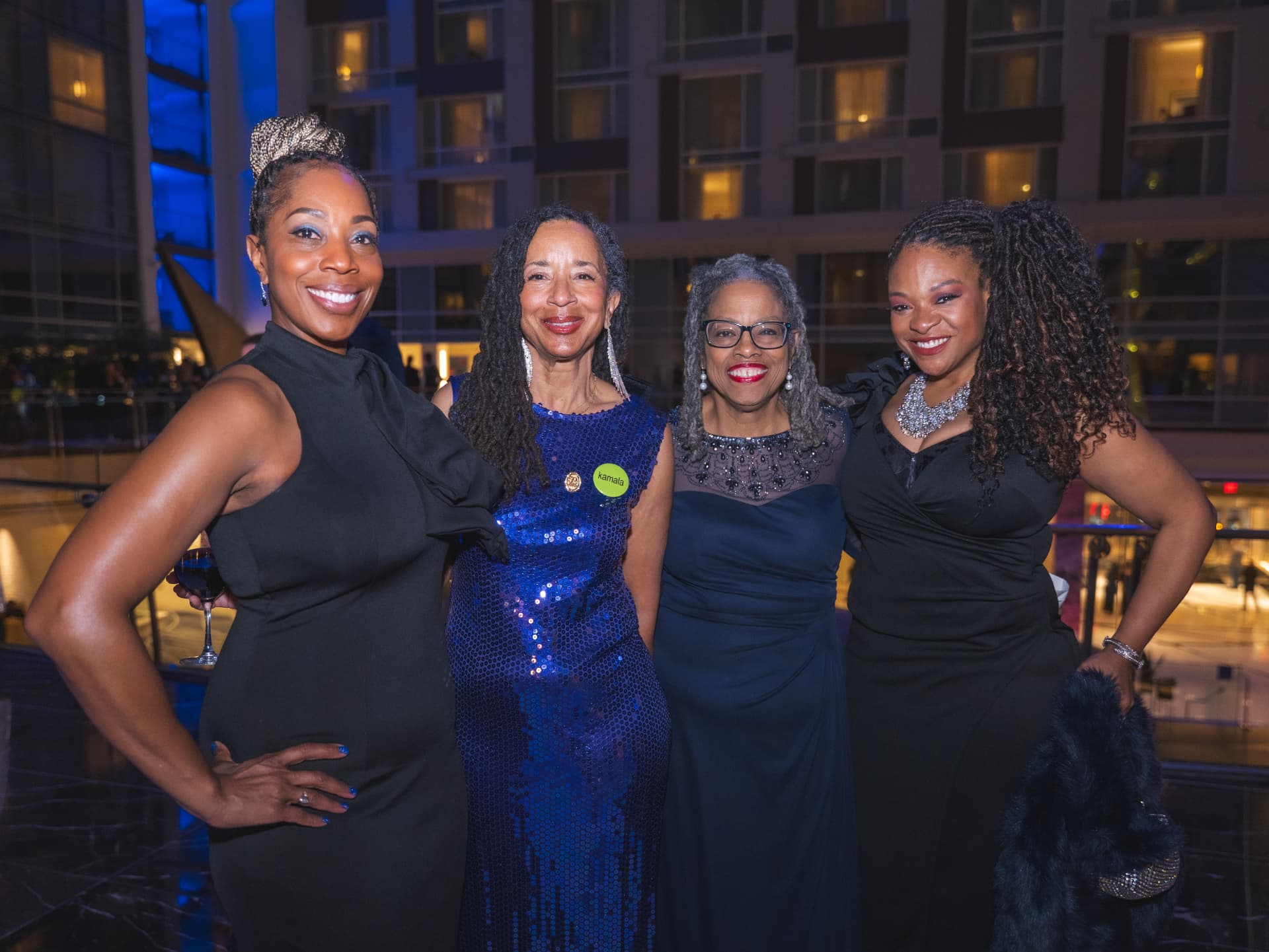 Four women in evening gowns posing together at the Charter Day Dinner